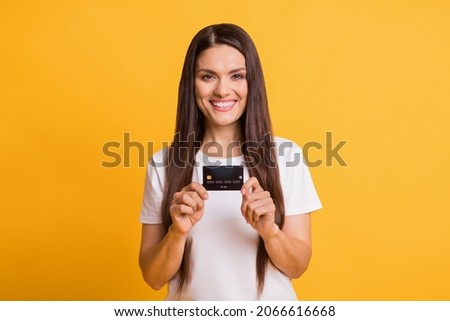 Photo portrait of happy business woman showing plastic bank wearing casual clothes isolated on vivid yellow color background