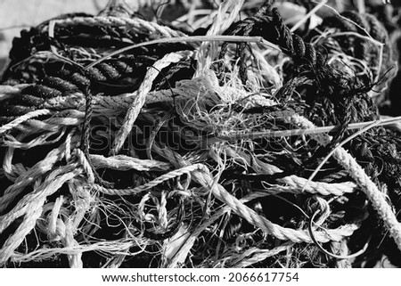 E Close colored black white old fishing twisted cotton ropes heap pile jumble detail. Concept tangle mess mix mishmash maze, environmental protection rubbish, pale tone, more in stock