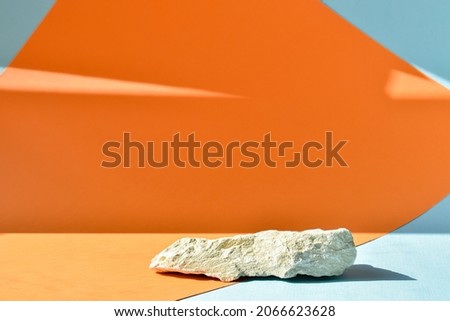 The podium is an orange-blue background with a stage, a stone showcase and a minimalistic background. Presentation of cosmetics.
