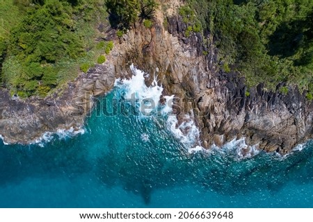 Amazing Aerial view of sea waves hitting rocks with turquoise sea water Beautiful seascape in the Phuket island coastline Thailand Travel and tour concept