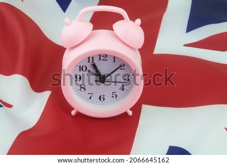 Alarm clock on British flag close-up. Event in United Kingdom concept.