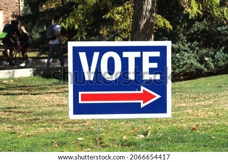 Red, white and blue sign directing people to vote. Election season in America. College campus
