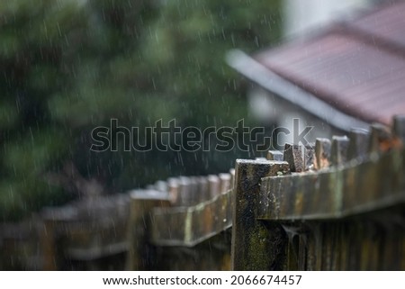 Wooden fence in the rain. Selective focus on one fence post. 