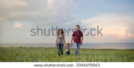 Caucasian family mom dad and little son at sunset. parents and toddler boy on the background of the sky. Freedom and an active lifestyle. Happy family relationships concept. banner. Place for text.