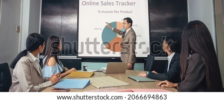 Asian manager leader present graph online sales tracker of product to team worker in meeting room.