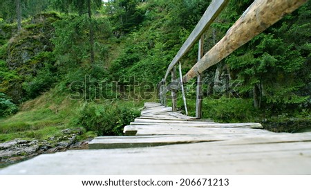 Old wooden bridge over Aries River in Apuseni Mountains.