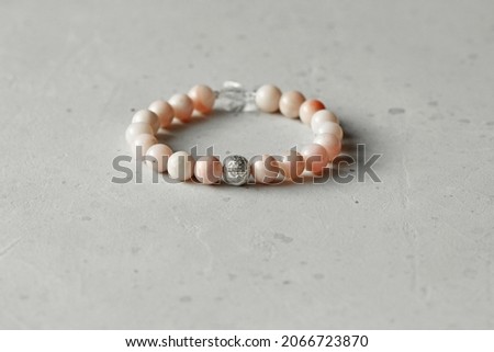 Pink opal bracelet. A bracelet made of stones on a hand from natural stone Pink opal. Bracelet made of natural stones. Handmade jewelry. Handmade bracelets on light modern background.