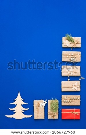 Wooden Christmas tree and gift boxes, flat lay, copy space. Winter holiday composition, trendy minimal style.