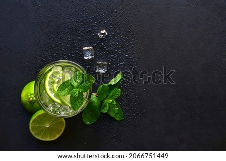 Delicious citrus cocktail mojito in a glass on a dark slate, stone or concrete background. Top view with copy space. Royalty-Free Stock Photo #2066751449