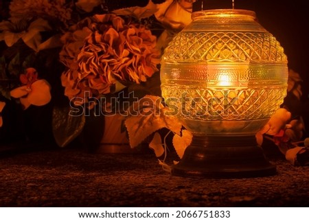 Large round orange grave lantern shining in the dark. Cemetery at night. Slavic Halloween tradition. All souls' day in Poland, Eastern Europe. Zaduszki. Royalty-Free Stock Photo #2066751833