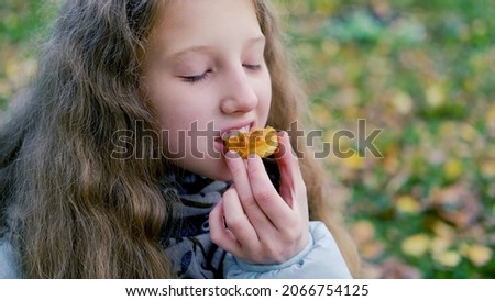 portrait of a little girl eating fresh honey with waffles at a picnic in autumn