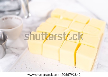 Unsalted butter sticks cut into cubes for preparing Italian buttercream frosting. Royalty-Free Stock Photo #2066793842