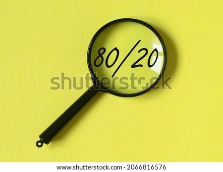 80 20 pareto principle concept, text through magnifying glass on yellow background. Royalty-Free Stock Photo #2066816576