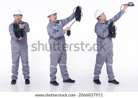 Full length portrait 50s 60s Asian elderly Man in Gray uniform hardhat as electric engineer, isolated. Electrical Technician male carry electronic cable plug over white background studio