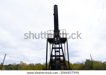 Oil pump oil rig energy industrial machine for petroleum. Wind power plantson background. Safe extraction of resources