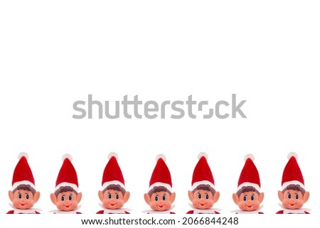 Christmas Elf toy peeking heads on an isolated white background with copy space. Christmas spirit, Christmas shelf tradition.