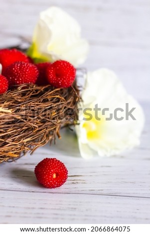 Fresh berries of Tibetan raspberries in a basket on a wooden background.