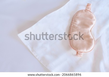 White silk pillowcase on the bed with a sleep mask. View from above
 Royalty-Free Stock Photo #2066865896