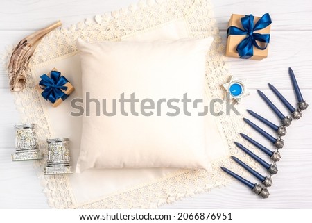 Jewish holiday Hanukkah concept with photo pillow mock up, menorah and gift box over white background