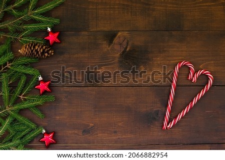 Christmas and New Year background. Christmas pine, Candy stick, dark wooden background. Wooden boards. A bright winter festive composition. Greeting card, banner, poster