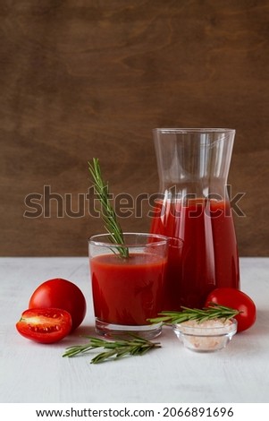 fresh Tomato juice with salt and rosemary. Bloody Mary cocktail with ingredients. Alcoholic drink with vodka and tomato juice in a glass isolated on a white background. copy space. vertical