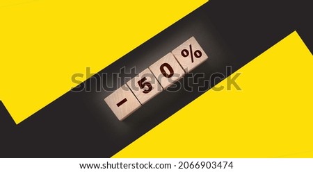 Minus 50 percent phrase on wooden blocks on black background. Sale business concept.