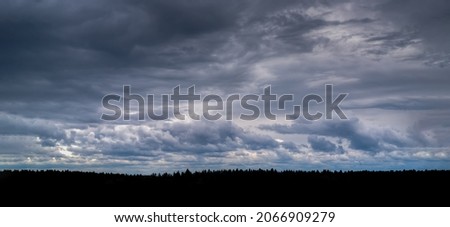 Dark storm clouds, wide panorama. Space,. Dark strip forest.