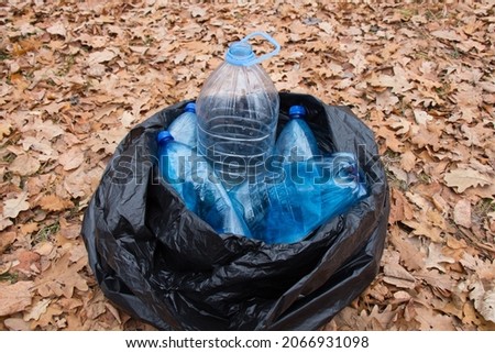 Plastic bottles waiting to be taken to recycle. Garbage collection campaign in the forest. Protecting animals from plastic debris.