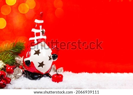 Festive New Year card with free space for text. Christmas gnome decorations in a snow on a red background