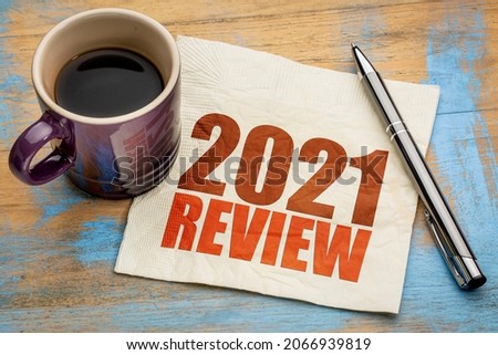 2021 year review text on a napkin with a cup of coffee, end of year business concept Royalty-Free Stock Photo #2066939819