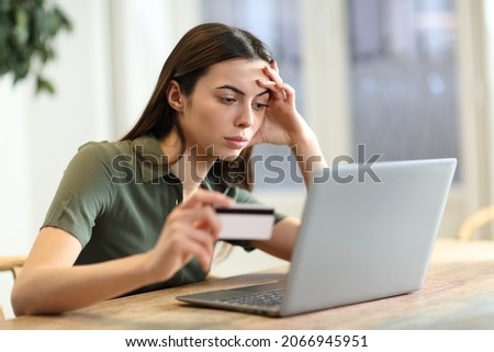 Worried woman having problem buying online with credit card and laptop at home Royalty-Free Stock Photo #2066945951