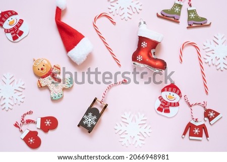 Vintage christmas decorations on a pink background. Festive New Year composition with svowflakes,snowman,christmas cookies,lollies and christmas toys. Greeting card. Flat lay.