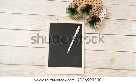 mockup tablet on a white wooden background with New Year's gifts , the concept of Christmas, gifts, black Friday and cyber Monday