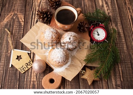cupcakes with a cup of coffee, pine cones, clock and decorations on a wooden table