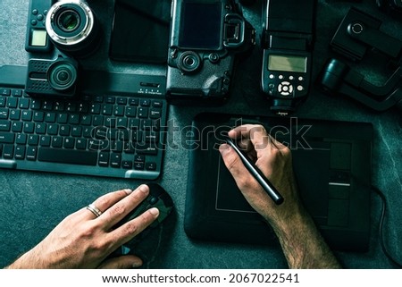 Professional Photographic Equipment and digital photo edit and retouching.Digital photo workstation over black background.Top view of  digital camera, flash,lens and laptop.