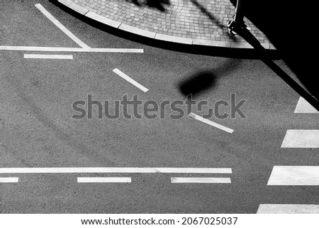 Shadows and road markings on city street in black and white, from above