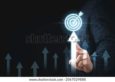 Hand touching up arrow with virtual target board for enhance and set up business objective target  goal concept.