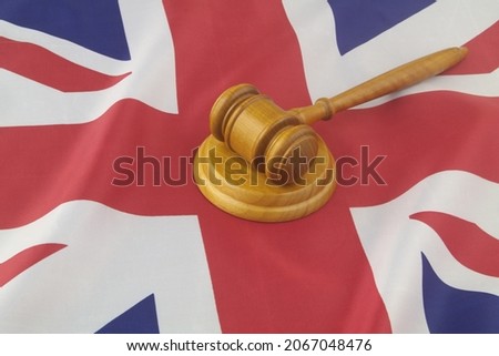 Wooden judge gavel on British flag. Court in UK concept.	