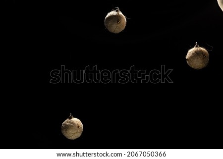 three christmas balls suspended on a black background