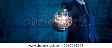 Businessman holding building of real estate icons. Engineering and construction. Investment and business development. Royalty-Free Stock Photo #2067069305