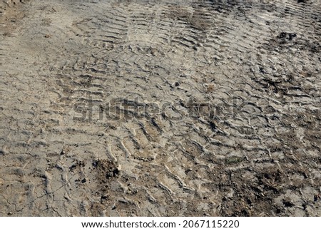 Hard and compacted soil has long been driven by excavators and heavy trucks. tire wear. the soil must be loosened before the garden can be established Royalty-Free Stock Photo #2067115220
