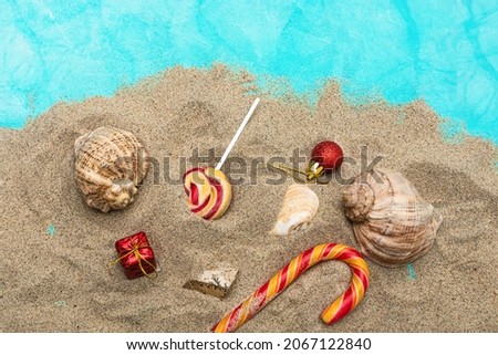 Sweets, gifts, seashells on the sand. Christmas sea travel concept.
