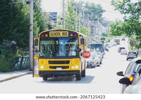 school bus with stop sign flashing on the street          