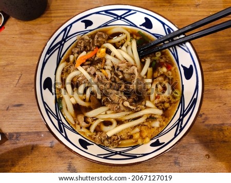 Top view of Beef Udon, a typical Japanese noodle dish with kakedashi soup, which is fish stock soup then topped with beef sukiyaki