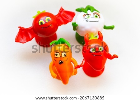 Small children's figurines of vegetables close-up on a white background.