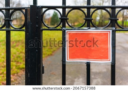 plate without an inscription hangs on the metal gate