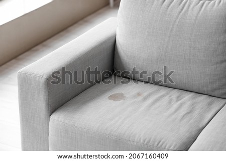 Dirty stain on grey sofa in living room Royalty-Free Stock Photo #2067160409