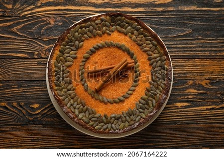 Delicious pumpkin pie with cinnamon on wooden background