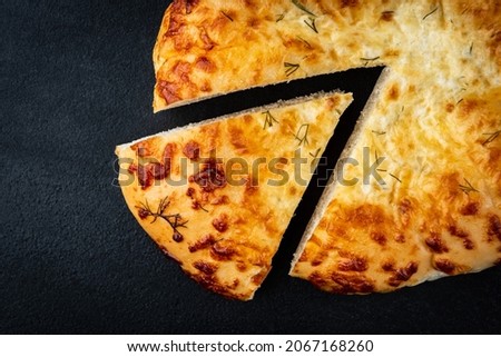 Sliced cheese bread (focaccia) on black background.