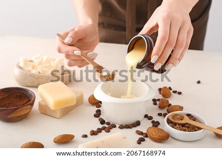 Woman making natural soap on light background Royalty-Free Stock Photo #2067168974